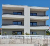 Ein Wohnhaus in der Stadt Vodice mit drei Stockwerken und verglasten Balkonen.