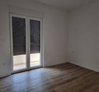 Ein Zimmer mit heruntergelassenen Jalousien und schwimmendem Boden in einer Vierzimmerwohnung.