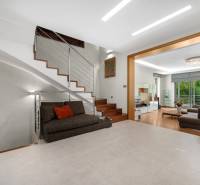 Innenraum eines Einfamilienhauses mit Sofa, Treppe und geräumigem Wohnzimmer mit Terrasse.