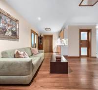 Wohnzimmer in einem Einfamilienhaus mit Sofa, Tisch und Kunstbild an der Wand.