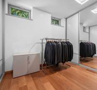 Ein Kleiderschrank in einem Einfamilienhaus mit einem Spiegelschrank und Kleiderbügeln für Kleidung.