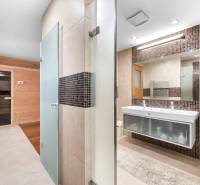 Badezimmer in einem Einfamilienhaus mit finnischer Sauna, zwei Waschbecken und Dusche.