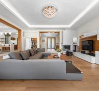 Wohnzimmer in einem Einfamilienhaus mit großem grauem Sofa und weißen Möbeln.