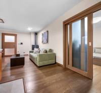 Wohnzimmer und Küche in einem Einfamilienhaus, mit Holzboden und Kamin.