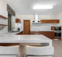Küche in einem Einfamilienhaus mit eingebauten Geräten und Holz-Küchenschränken.