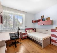 Kinderzimmer in einem Einfamilienhaus mit Bett, Schreibtisch und Dekorationen.