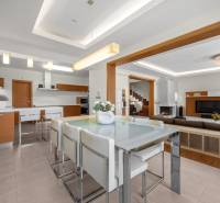 Innenraum eines Einfamilienhauses mit Esstisch, Küchenzeile, Wohnzimmer und Treppe.