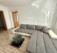 Helles Wohnzimmer mit Ecksofa und Glastisch in einer 2-Zimmer-Wohnung.