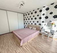 Schlafzimmer in einer 2-Zimmer-Wohnung mit Bett, Einbauschrank und Schminktisch.