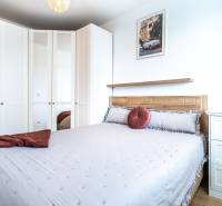 Schlafzimmer in einer 2-Zimmer-Wohnung mit großem Schrank, Bett und Wanddekorationen.