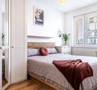 Helles Schlafzimmer in einer 2-Zimmer-Wohnung mit bequemem Bett und dekorativen Kissen.