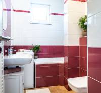 Badezimmer in einer 2-Zimmer-Wohnung mit Waschbecken, Badewanne und Fenster.