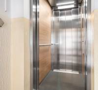 Öffnen eines modernen Aufzugs auf der Etage eines Wohnhauses mit Holzdekor.