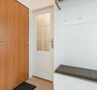Weißes Interieur mit Türen und Bank in einer Zweizimmerwohnung.