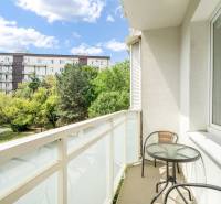 Der Balkon der 2-Zimmer-Wohnung bietet einen Blick auf Grünflächen und Wohnhäuser in Bratislava.