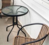 Balkon mit Rattanstühlen und Glastisch in einer 2-Zimmer-Wohnung.