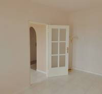 Fliesen in einer 3-Zimmer-Wohnung, weiße Türen mit Verglasung und eine Stehlampe.