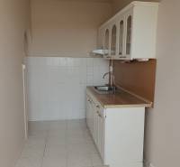 Küche mit weißen Schränken und Spüle in einer 3-Zimmer-Wohnung.