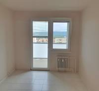 Ein Zimmer in einer 3-Zimmer-Wohnung mit Fliesen, Heizkörper und Balkontür.