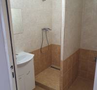 Badezimmer einer 3-Zimmer-Wohnung mit Badewanne und Waschbecken, gefliest mit hellen Keramikfliesen.