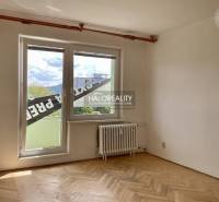 Ein Zimmer mit Parkettboden und einem großen Fenster in einer 3-Zimmer-Wohnung.