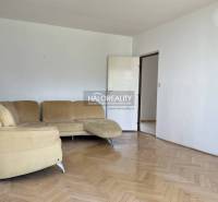 Wohnzimmer in einer 3-Zimmer-Wohnung mit beigem Sofa und Parkettboden.
