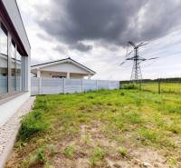 Garten bei einem Einfamilienhaus in der Martin Benku Straße in Kostolište, mit Stromleitungen im Hintergrund.
