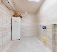 Badezimmer in einem Einfamilienhaus mit Fliesen und Boiler auf der rechten Seite.
