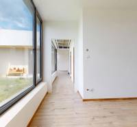 Der Flur in einem Einfamilienhaus mit einem großen Fenster und Blick auf den begrünten Außenbereich.
