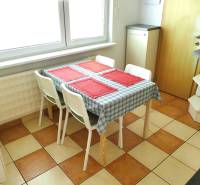 Esszimmer mit Holztisch und vier Stühlen in einer 3-Zimmer-Wohnung, kariertem Boden.