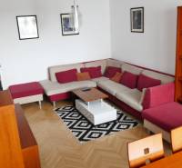 Wohnzimmer einer 3-Zimmer-Wohnung mit Ecksofa und Holzmöbeln.