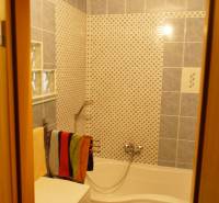 Badezimmer mit Dusche in einer 3-Zimmer-Wohnung, mit Keramikfliesen bedeckt.