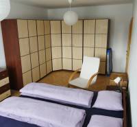 Schlafzimmer in einer 3-Zimmer-Wohnung mit einem großen Eckschrank und einem Sessel.