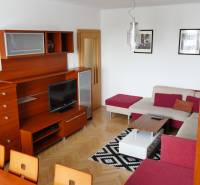 Wohnzimmer in einer 3-Zimmer-Wohnung mit einer Holzwand-Einheit und einer Ecksofagarnitur.