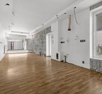 Geräumige Geschäftsräume mit Holzboden und Spiegeln an der Wand.