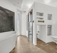Weißes Badezimmer mit Badewanne, Dusche und hängendem WC in Geschäftsräumen.