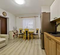 Küche und Essbereich in einer 2-Zimmer-Wohnung mit hellen Möbeln und Holzboden.