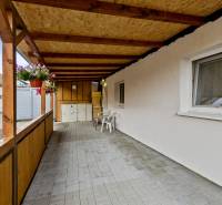 Überdachte Terrasse neben einer 2-Zimmer-Wohnung in Malé Leváre mit Blumendekorationen.