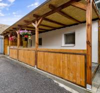 Holzterrasse bei einer 2-Zimmer-Wohnung in Malé Leváre, umgeben von Blumen.