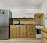 Küche mit Herd und Kühlschrank in einer 2-Zimmer-Wohnung.