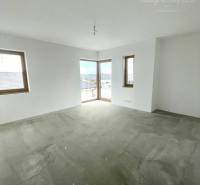 Leerer Raum in einem Einfamilienhaus mit weißen Wänden und Betonboden.