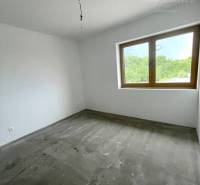 Ein Zimmer in einem Einfamilienhaus mit weißen Wänden und einem großen Fenster.