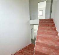 Im Einfamilienhaus gibt es Betontreppen und weiße Wände, die in den oberen Stock führen.