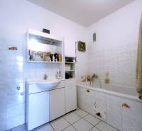 Badezimmer in einer 3-Zimmer-Wohnung mit Badewanne, Waschbecken und Stauraum.