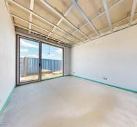 Innenraum in einem Einfamilienhaus mit unfertiger Decke, großes Fenster, Blick auf den Hof.