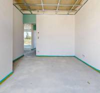 Interieur eines unmöblierten Raumes in einem Einfamilienhaus mit Blick auf die Landschaft draußen.