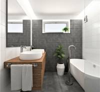 Badezimmer in einem Einfamilienhaus mit Badewanne, Waschbecken auf einer Holzplatte und Fenster.