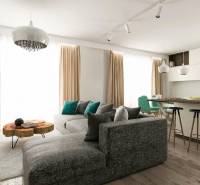 Wohnzimmer eines Einfamilienhauses mit bequemer Couch, Kücheninsel und Holzelementen.