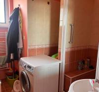 Badezimmer in einer 3-Zimmer-Wohnung mit Waschmaschine und Duschkabine.