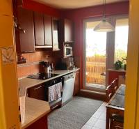 Küche mit Holzschränken und Essecke in einer 3-Zimmer-Wohnung.